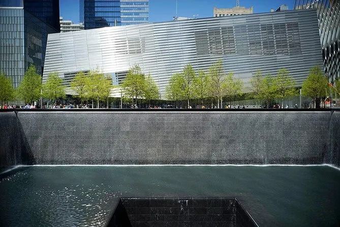 The 9/11 Memorial reflecting pool with the Museum pavilion behind the trees