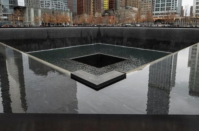 A reflecting pool with water falling into the central void